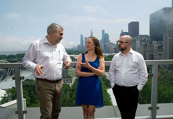 Three coworkers meeting on office terrace overlooking the city