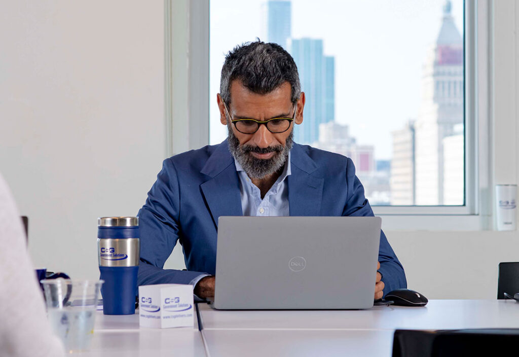 Male CSG employee typing on laptop in a conference room